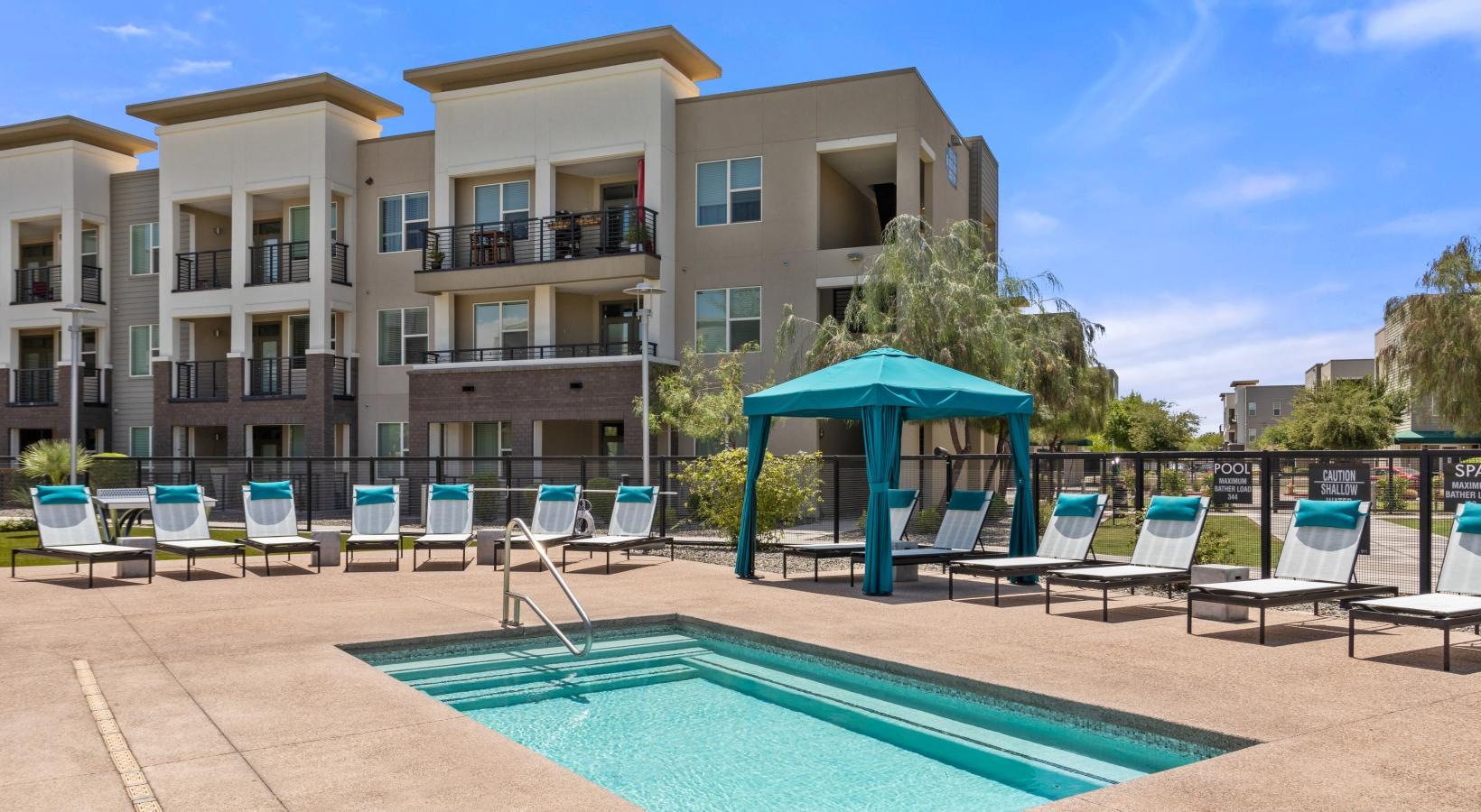Relax and unwind poolside a pool with chairs around it